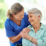 nurse-holding-senior-woman-and-smiling