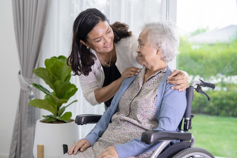 loved one caring for an elderly family member in a wheelchair