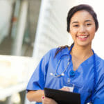Smiling nurse with clipboard and documents.