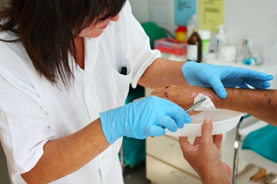 Healthcare professional treating a wound in an elderly patient