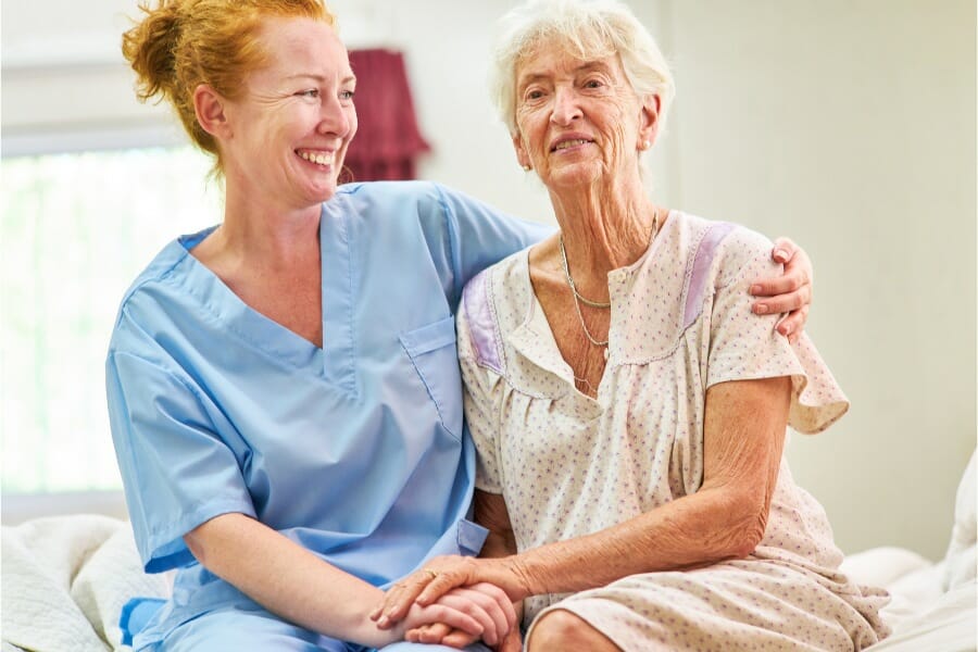A smiling registered nurse and an elderly patient with AD