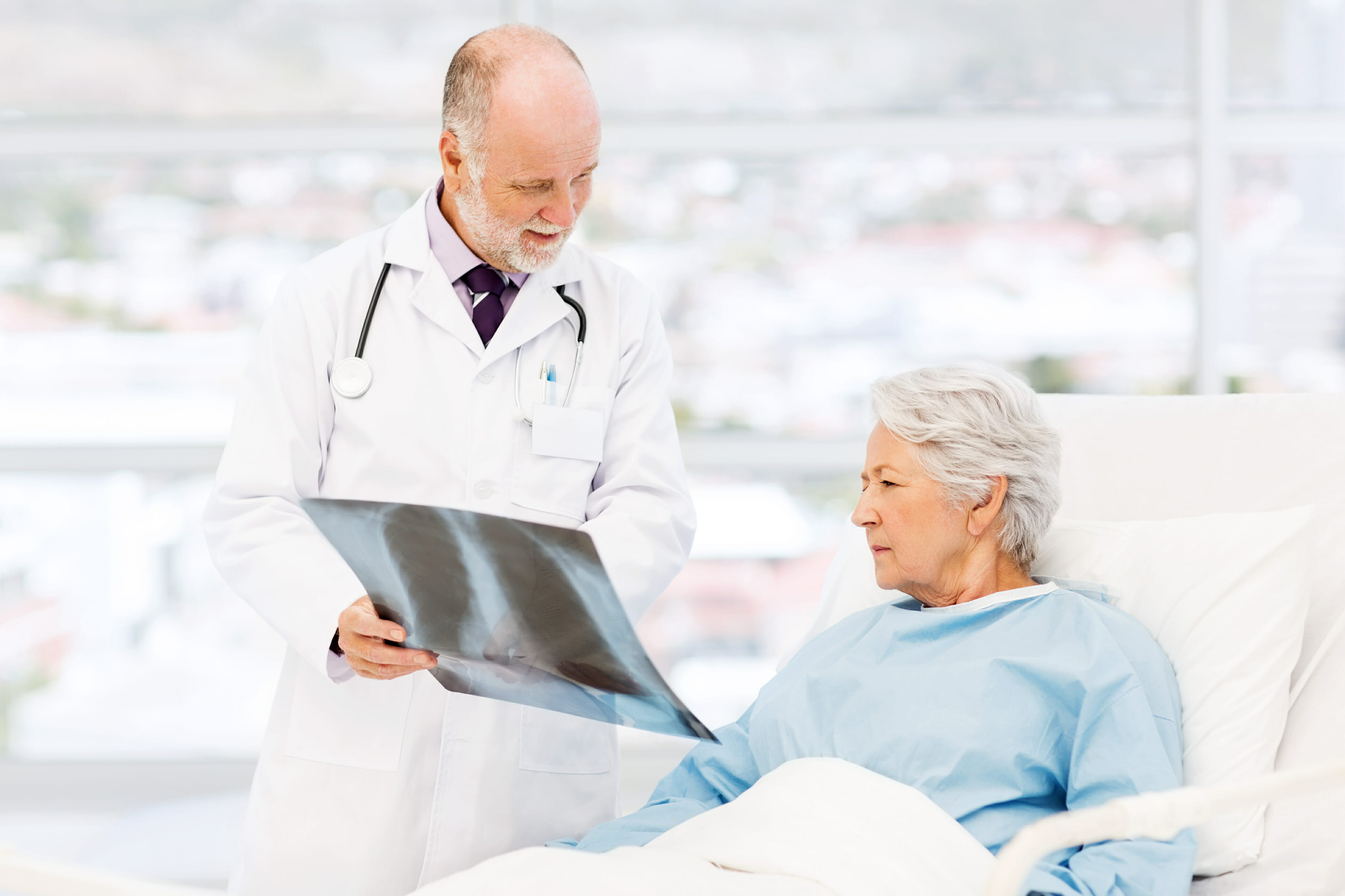 Doctor Showing X-Ray To Patient In Hospital