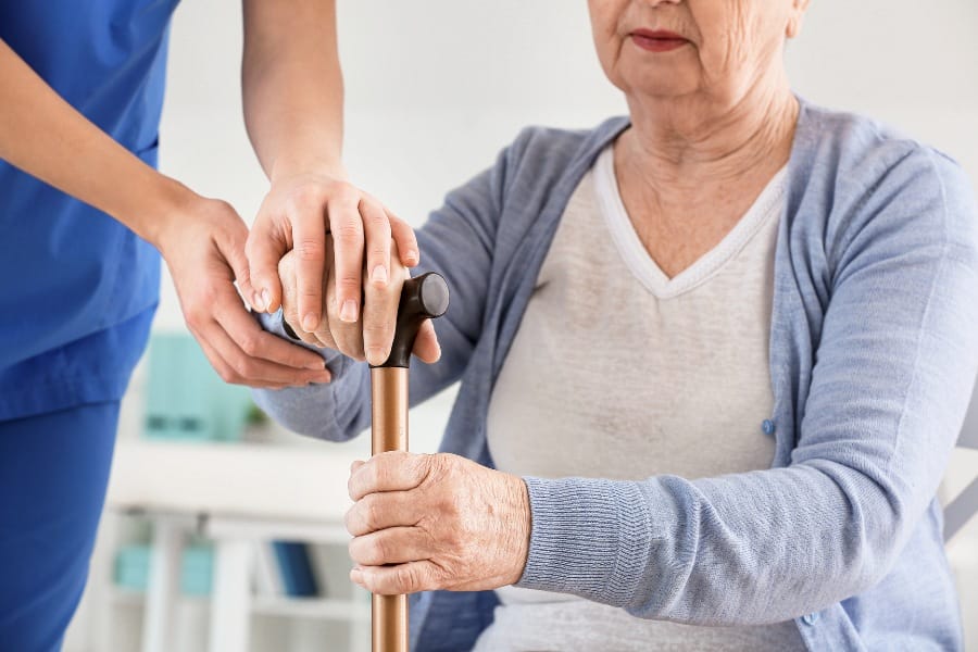 A woman suffering from parkinson's disease with a caretaker