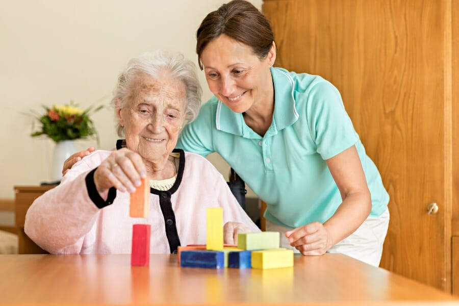 OT helping an elderly patient with an activity