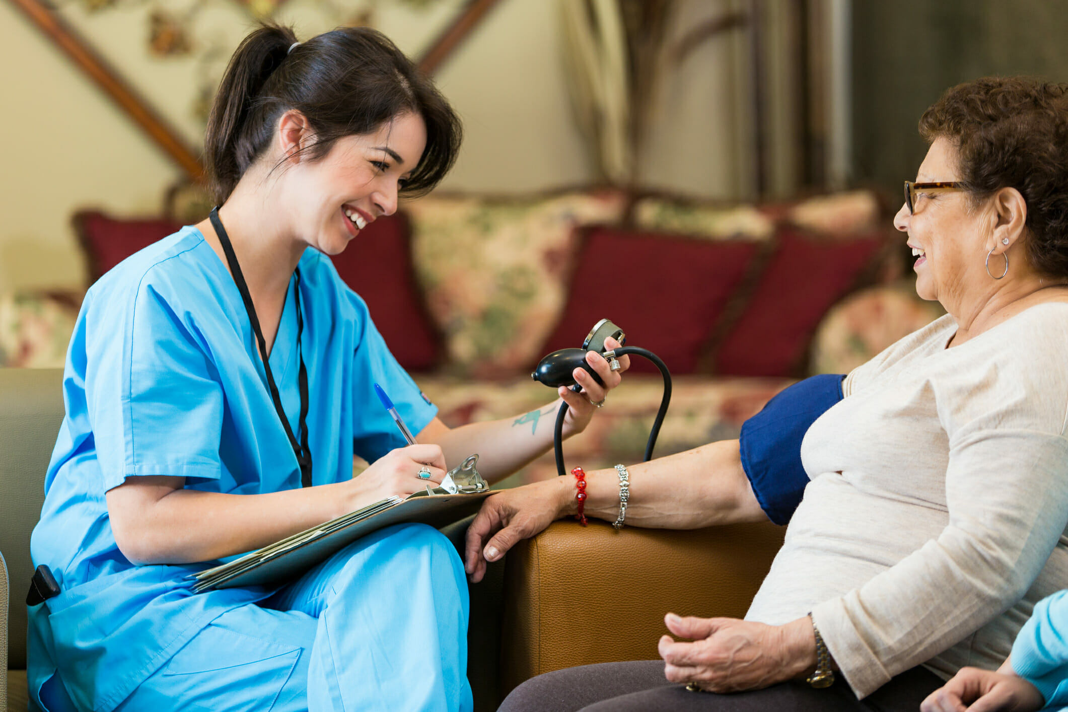 Home healthcare nurse checks patient's blood pressure