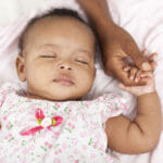 3 month old baby girl sleeping holding her mother's hand