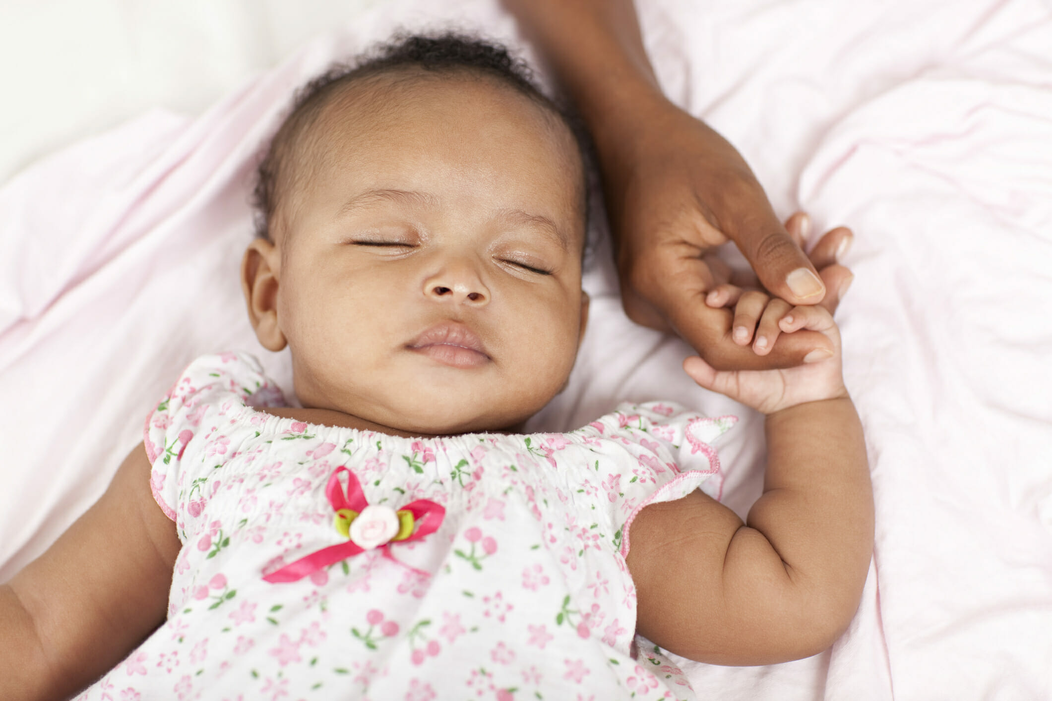 3 month old baby girl sleeping holding her mother's hand