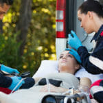 nurses checking patients eyes in front of ambulance