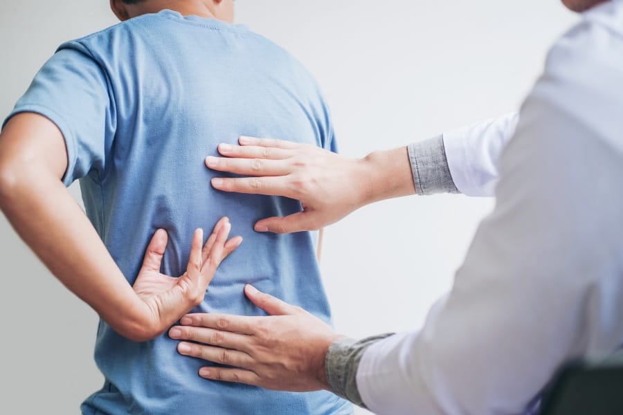 Physical therapist examining a patient's back