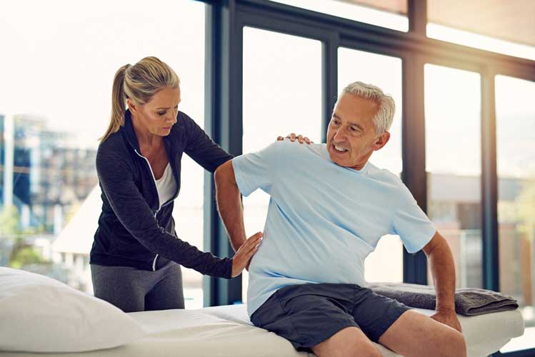 Adult man undergoing physical therapy program with his physical therapist