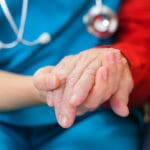 Nurse holding hands with an Alzheimer's patient