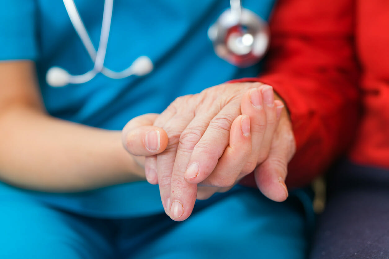 Nurse holding hands with an Alzheimer's patient