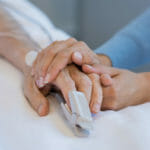 Patient holding hands with medical professional