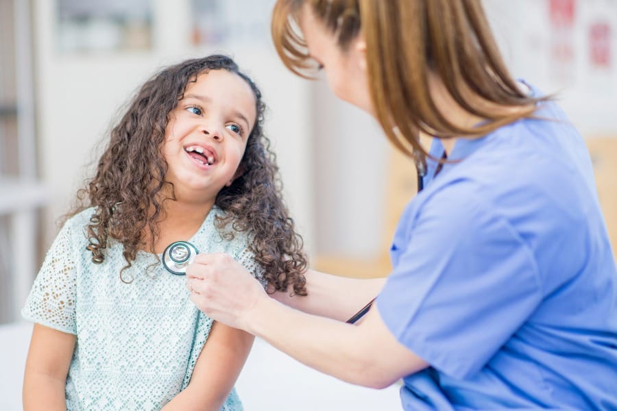 A pediatric nurse assisting a young patient