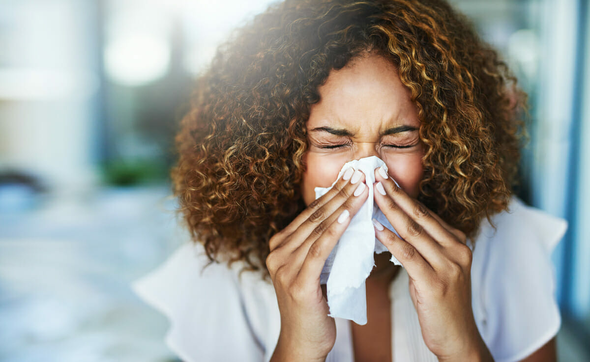 woman-sneezing-into-tissue