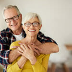 senior man and woman hugging and smiling