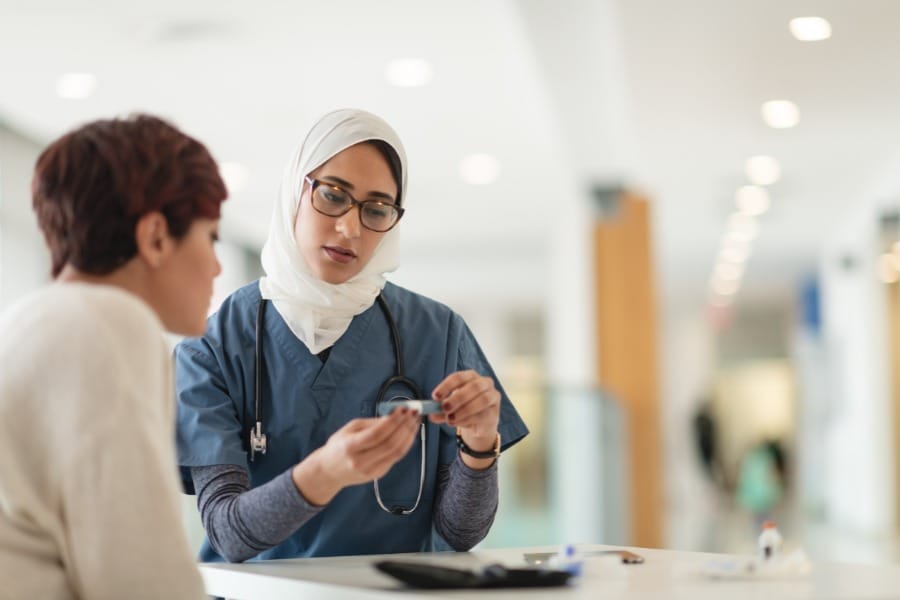 home nurse checking a patient's blood sugar