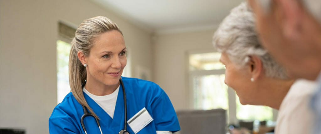 female nurse at care facility with senior couple