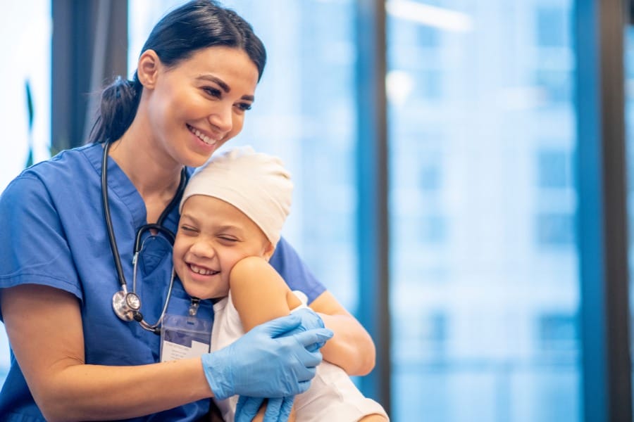 Nurse hugging her young patient at a medical facility