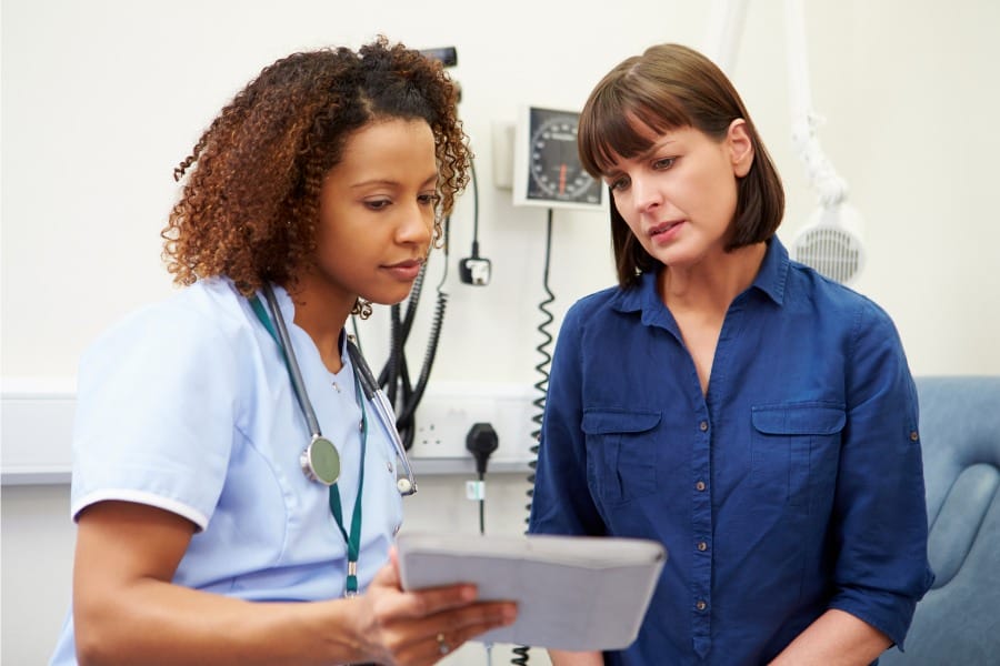 Nurse and patient checking records and charts