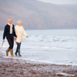 senior couple walking along the beach