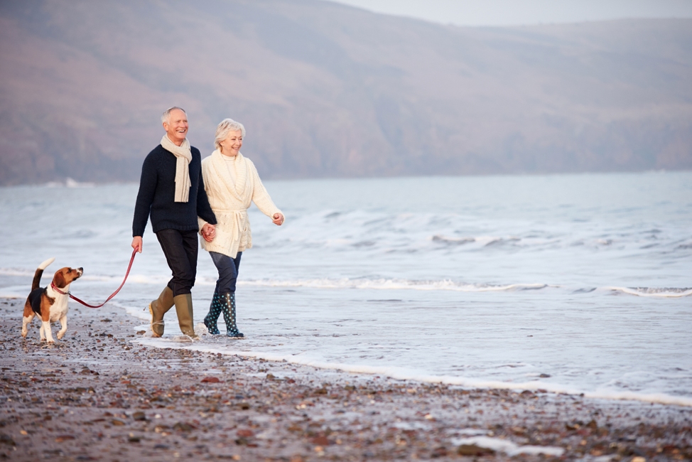senior couple walking along the beach