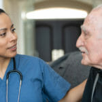 female nurse at home with senior man