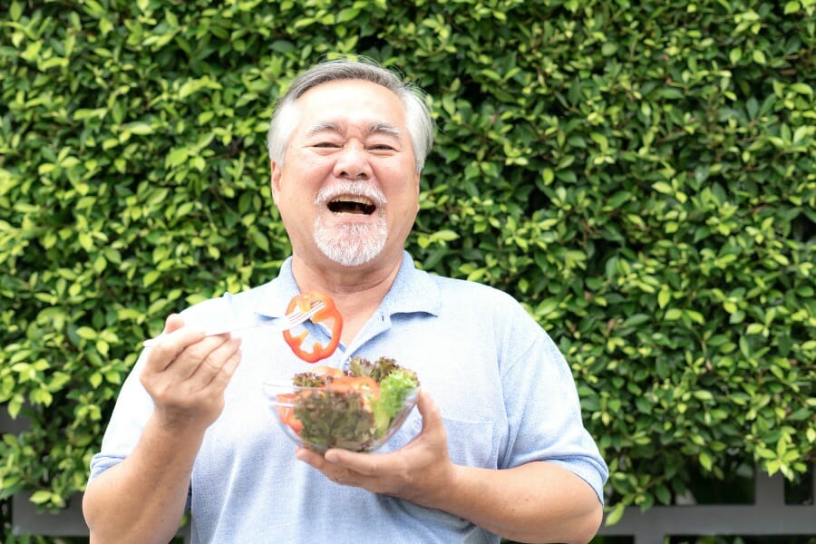 Elderly man eating a healthy salad