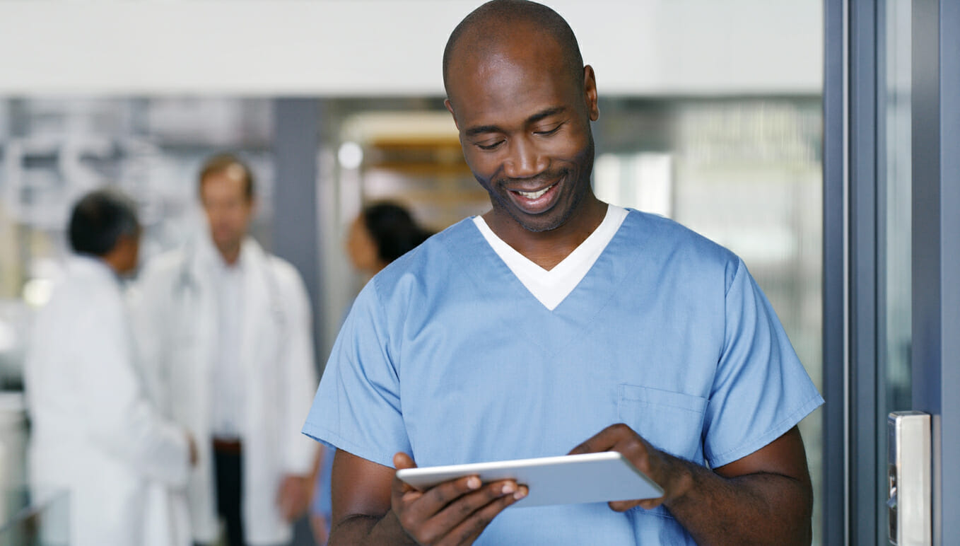 nurse in medical facility reading and smiling