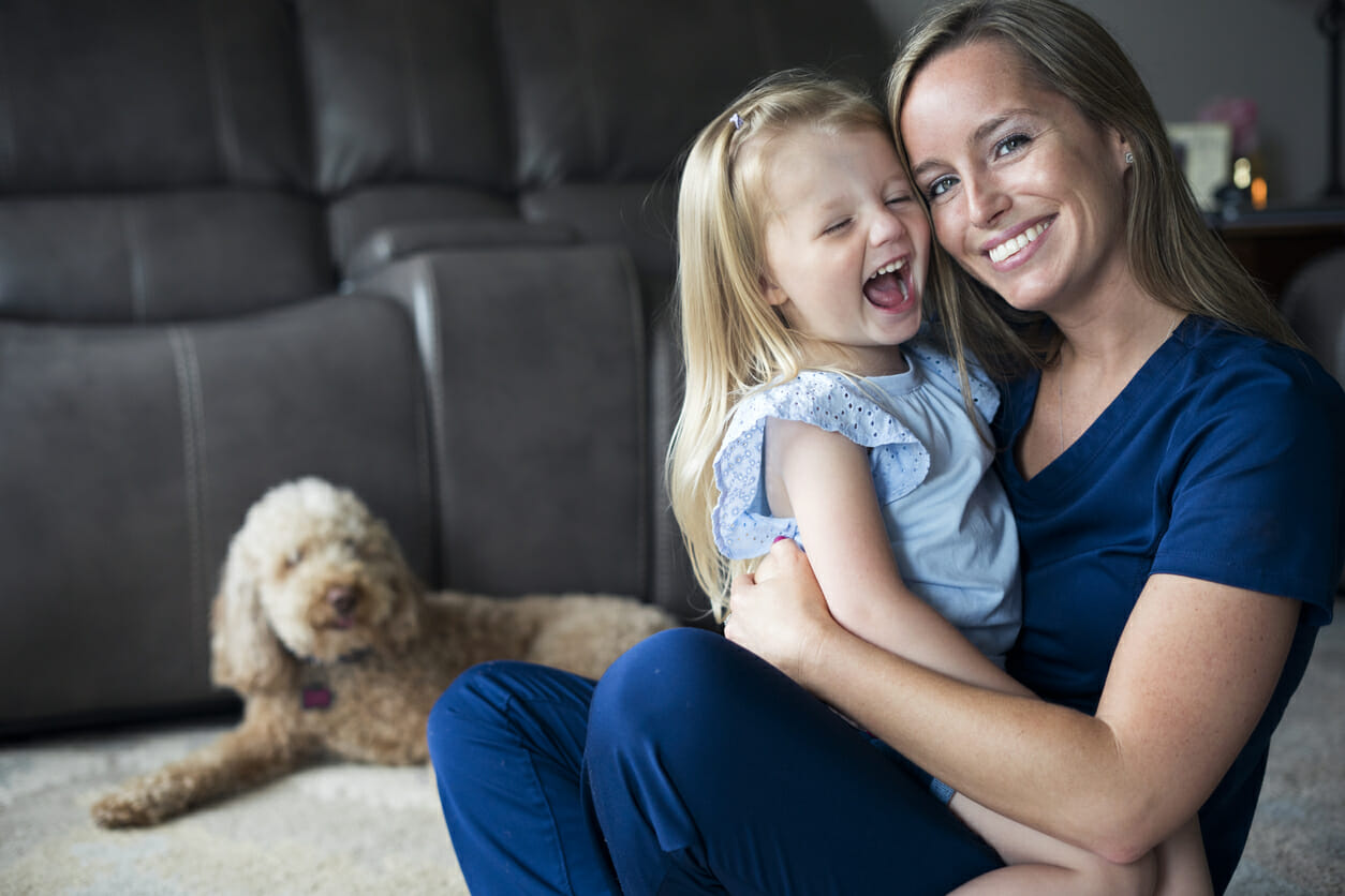 nurse mom at home with daughter and dog