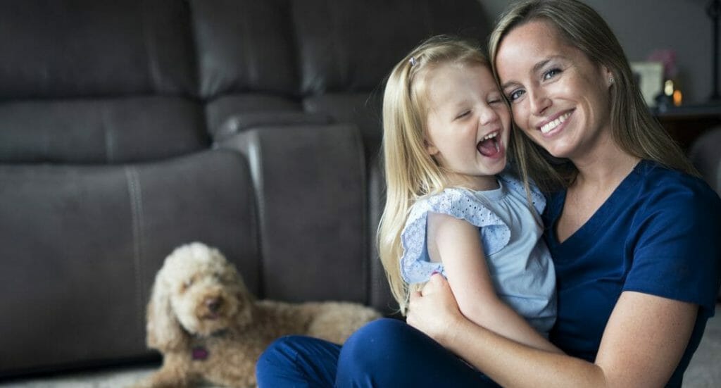 nurse at home with daughter and golden doodle