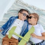 children playing and relaxing in the summer sun wearing sunglasses