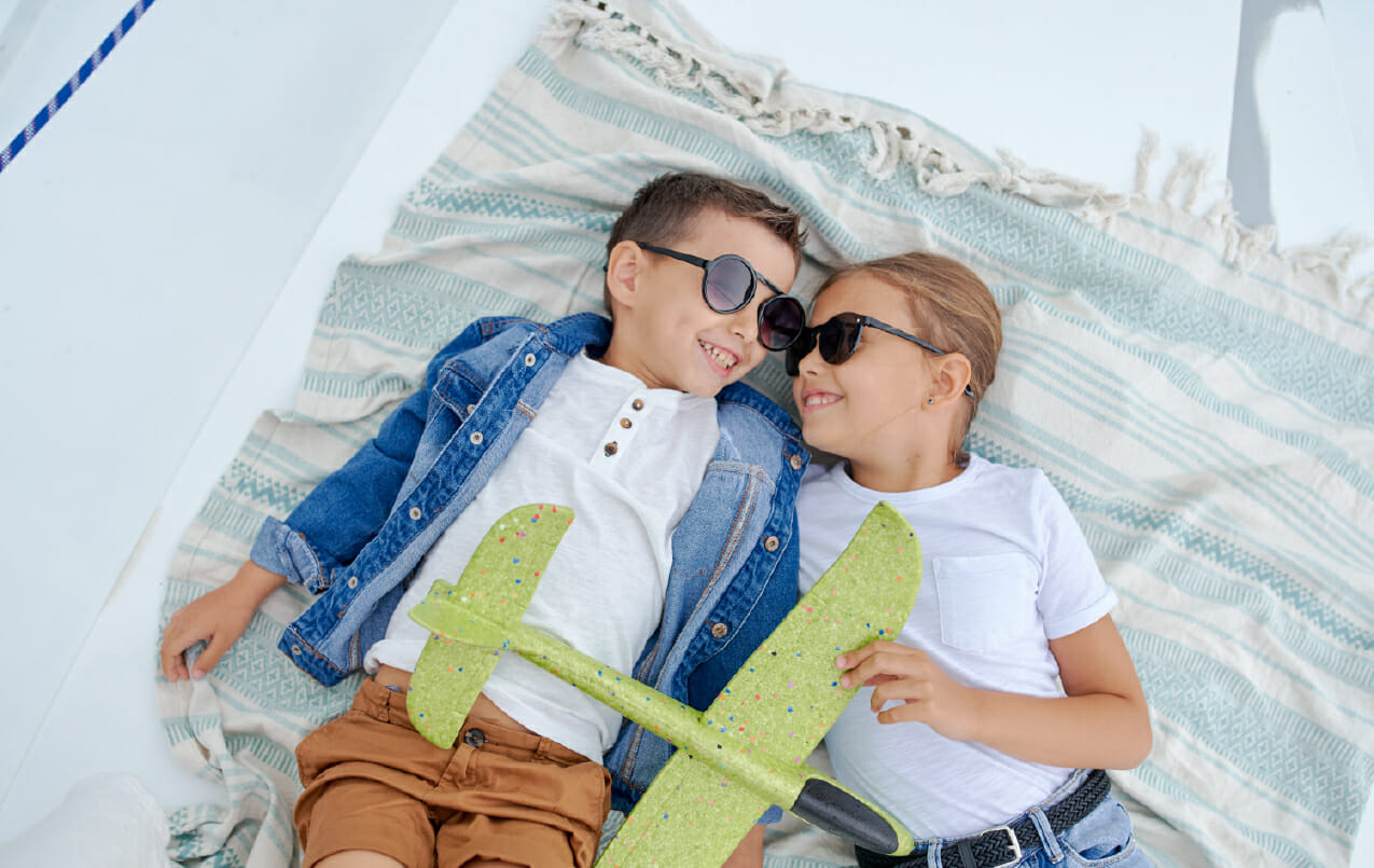 children playing and relaxing in the summer sun wearing sunglasses