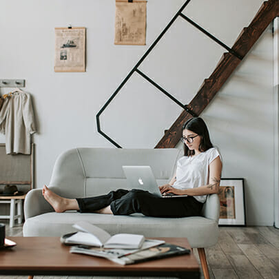 nurse sitting on sofa working on laptop