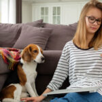 nurse applying for job looking at phone and beagle next to her