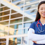 Nurse standing confidently in front of building