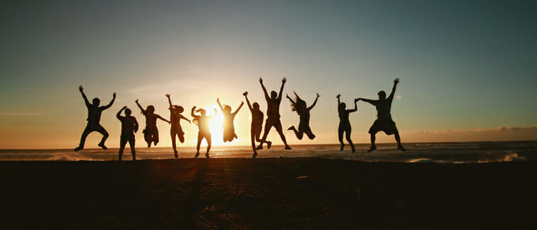 group jumping for joy at a beach