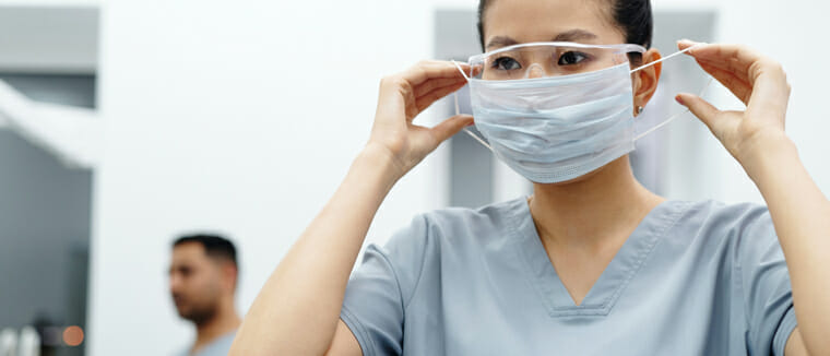 nurse putting on goggles and mask