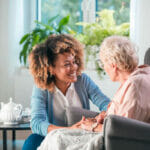 Nurse reassuring patient at home