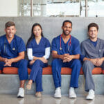 nurse team sitting together on bench in hospital