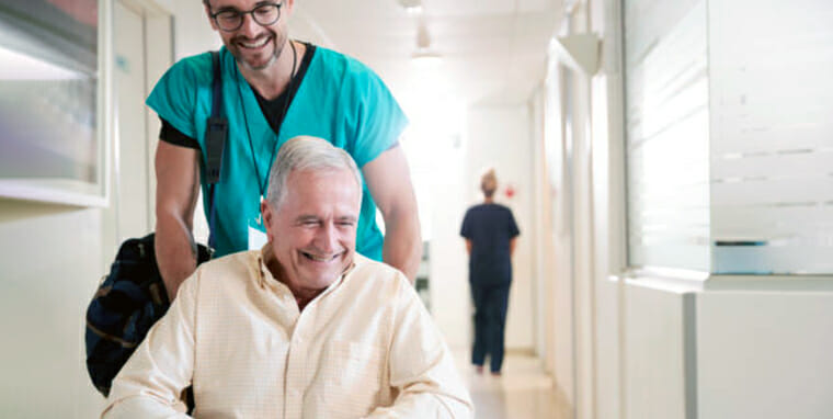 older man leaving hospital with private nurse