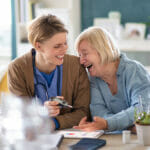 private-nurse-client-laughing-together-at breakfast table