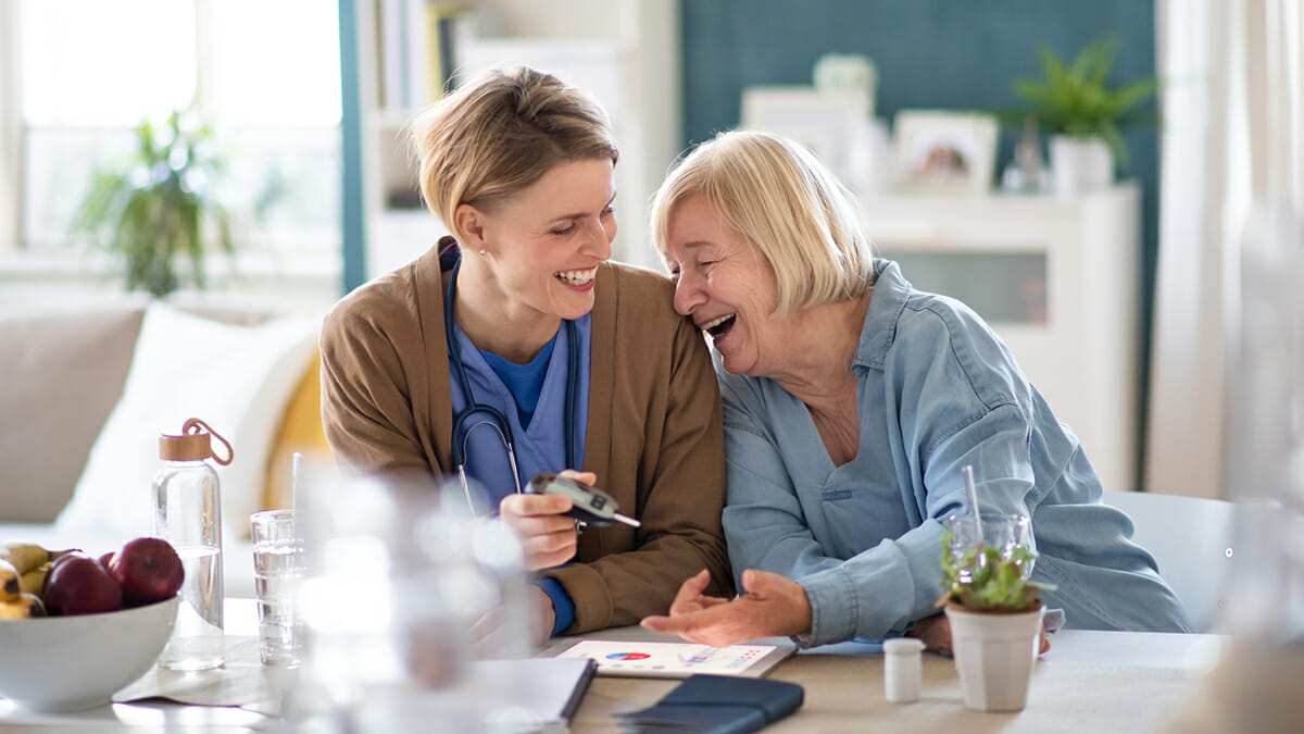 private-nurse-client-laughing-together-at breakfast table