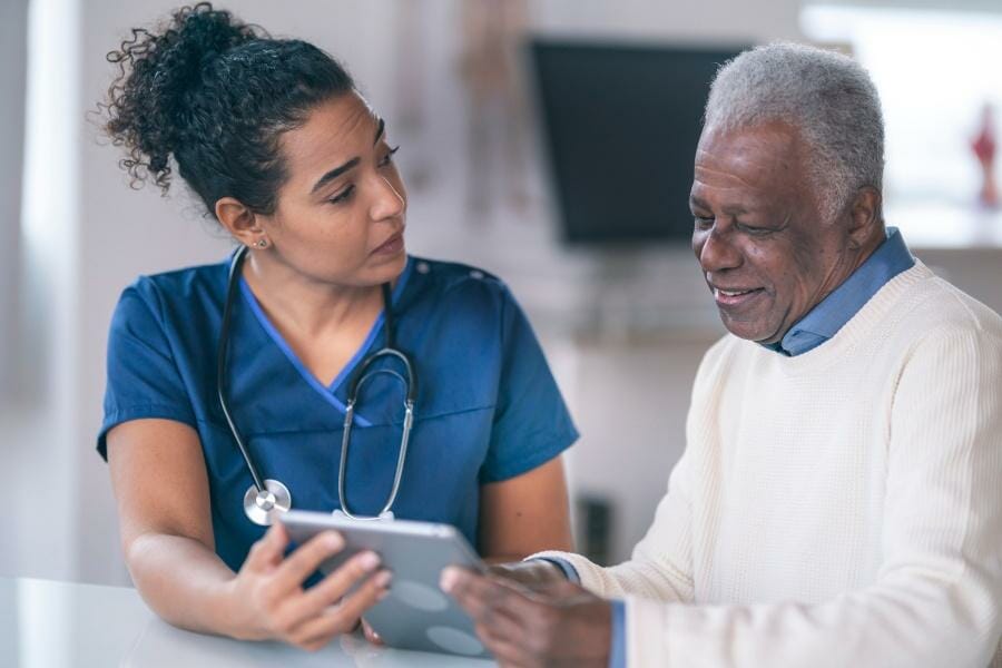 healthcare staffing A nurse helping a patient fill out information and paperwork.