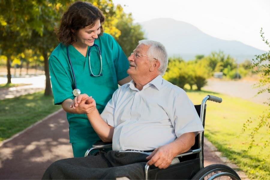 Private duty nurse and her elderly patient in a wheelchair.