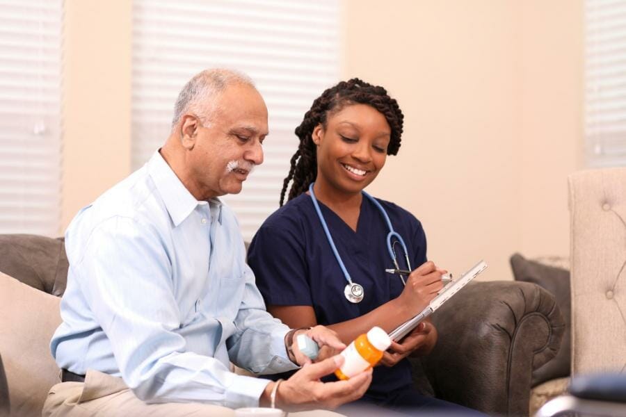 A home health nurse assisting her patient with medication management.