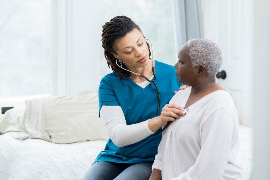 Private nurse checking the heartbeat of a patient.