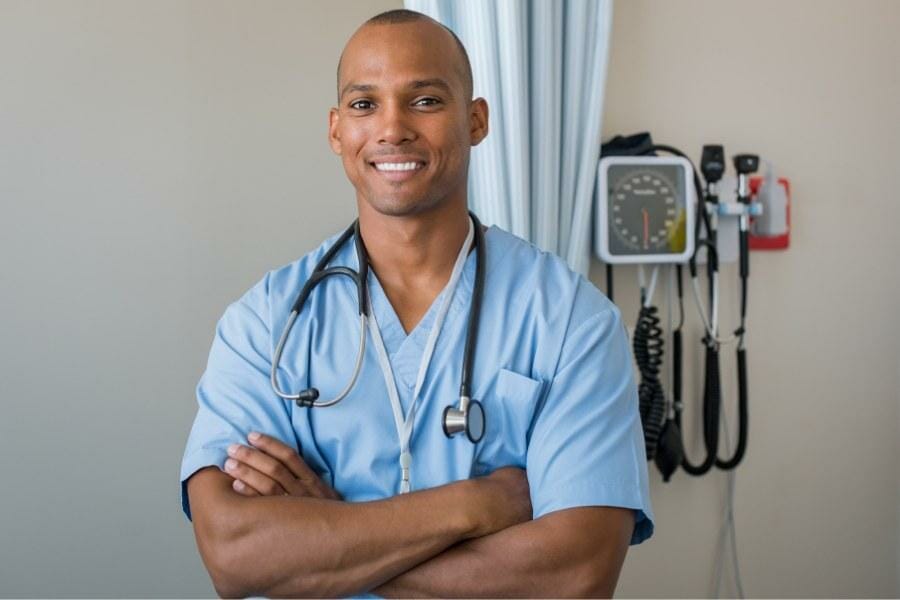 A smiling nurse with his arms crossed in San Mateo.