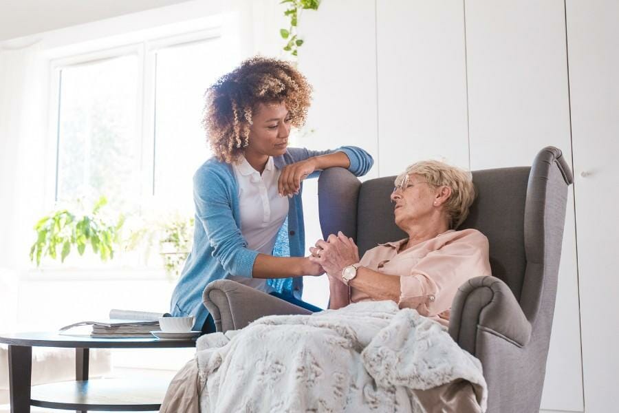 A home nurse assisting an elderly patient with medication management.