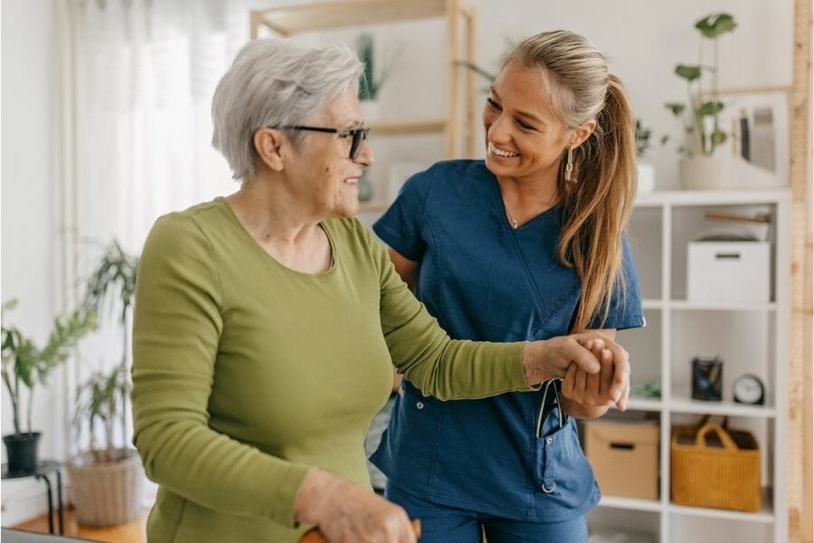 A private nurse helping a client walk